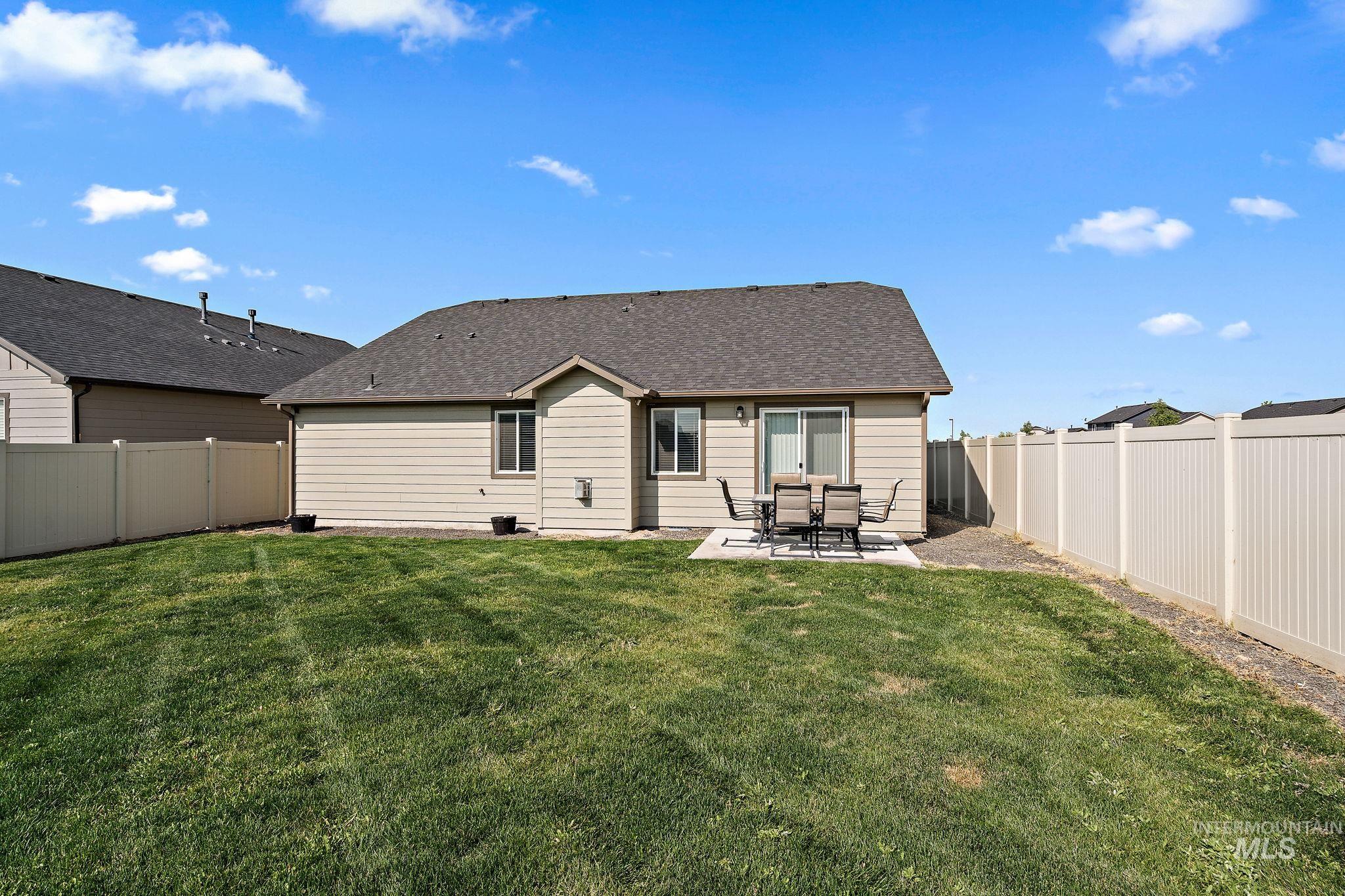 Rear view of house with a patio area, a fenced backyard, and roof with shingles