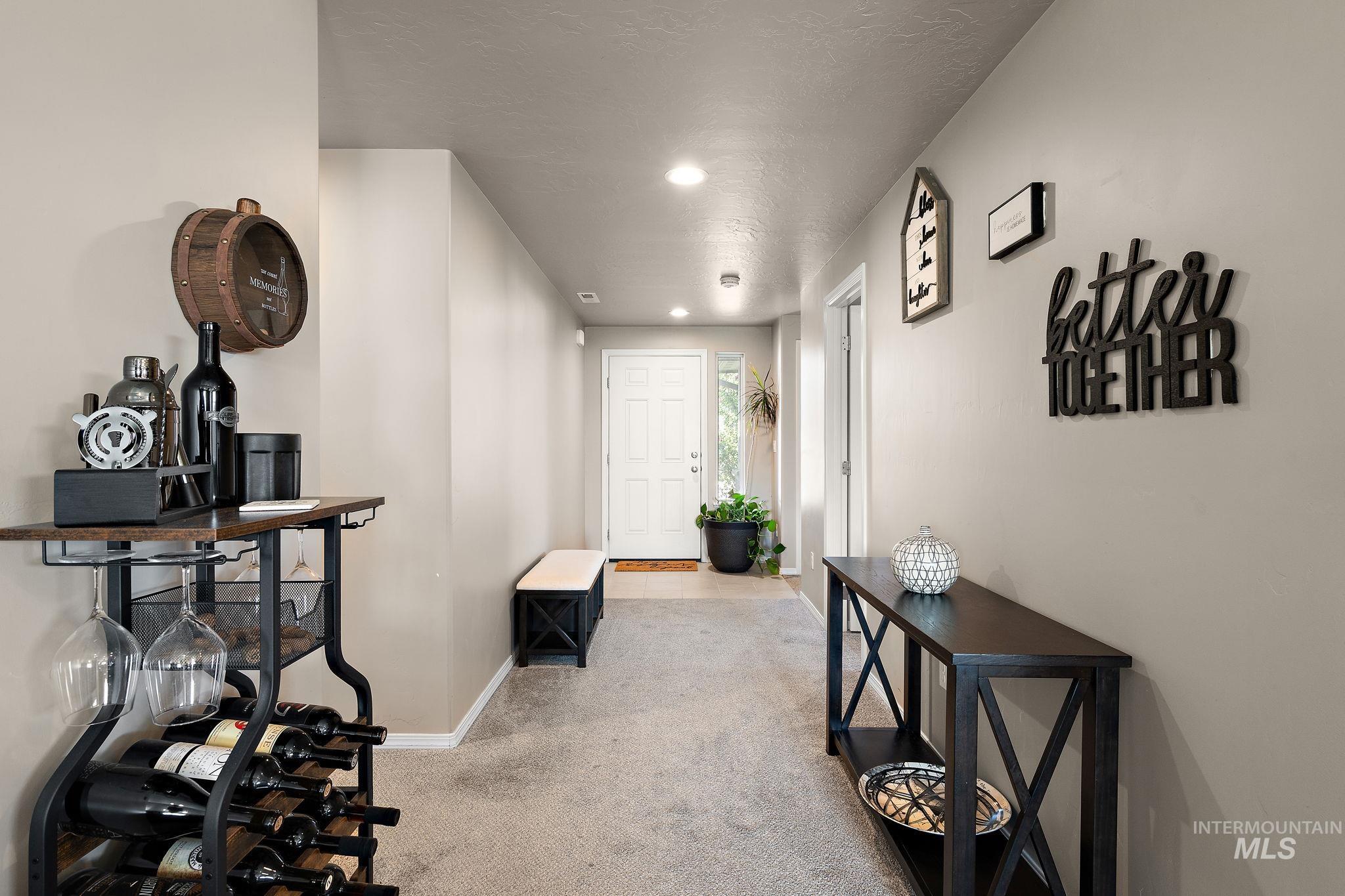 Hallway with light carpet, a textured ceiling, and recessed lighting