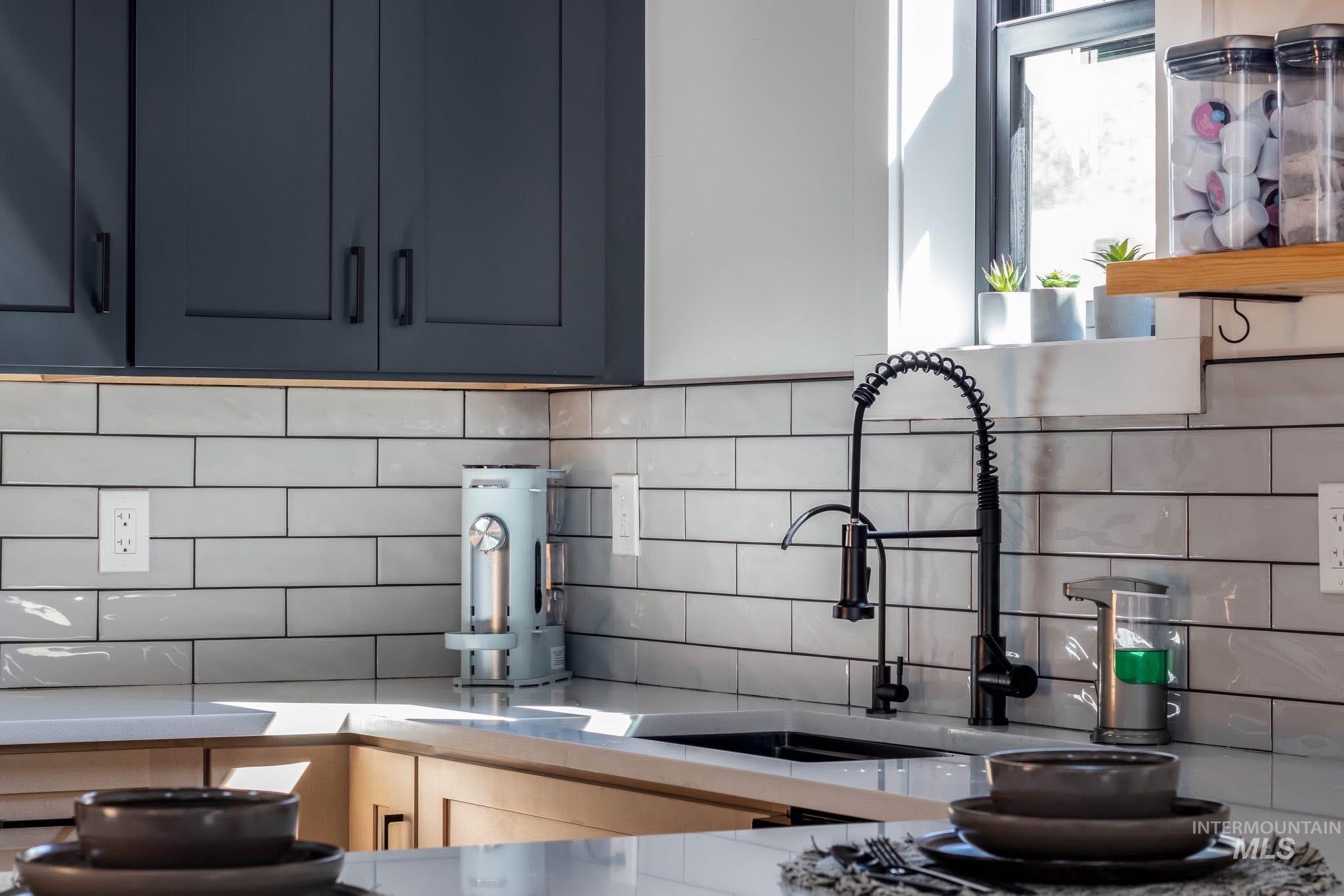 Kitchen with backsplash and light stone counters
