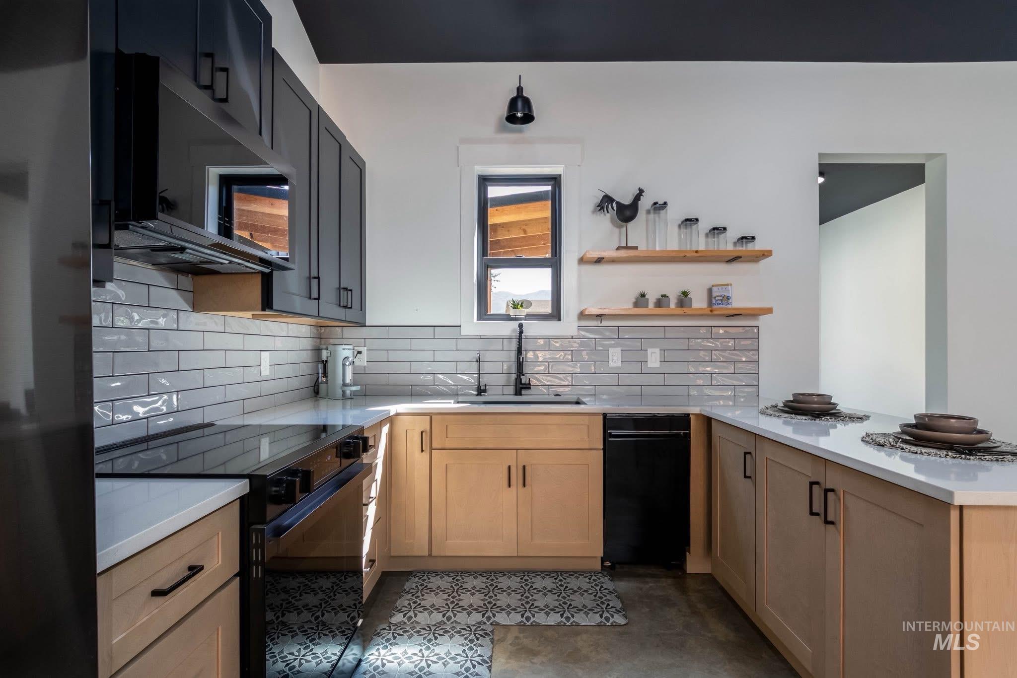 Kitchen with black appliances, a peninsula, tasteful backsplash, open shelves, and light stone counters