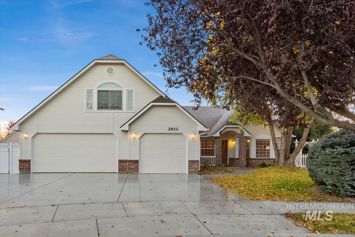 Traditional home featuring brick siding, driveway, and an attached garage