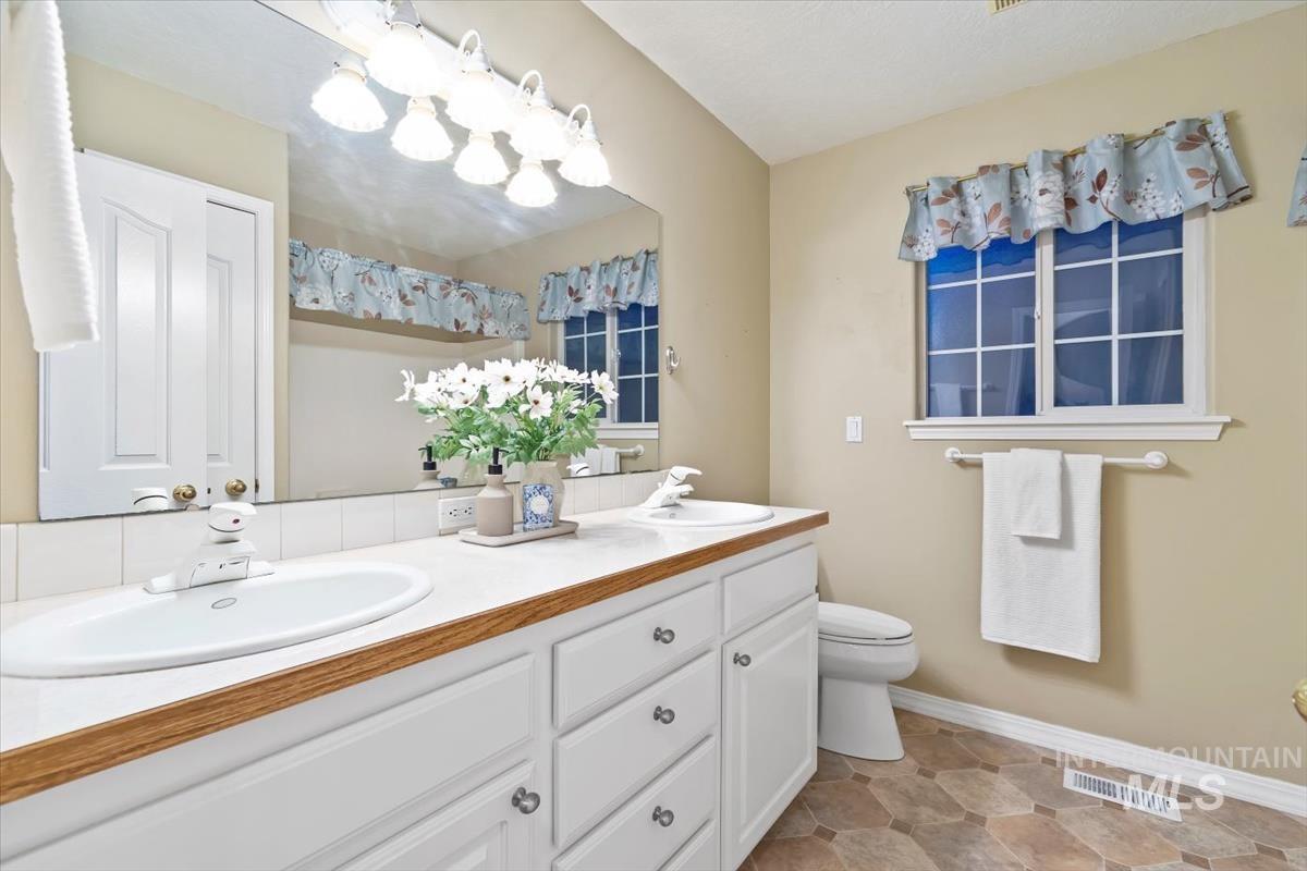 Full bathroom featuring double vanity and light tile patterned floors