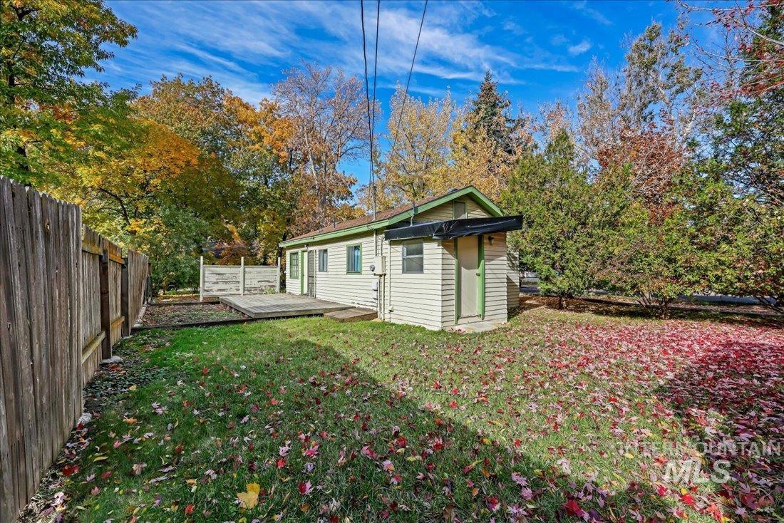 Rear view of property featuring a wooden deck, a fenced backyard, and an outbuilding