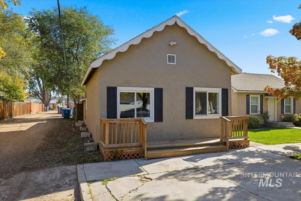 Back of house featuring a wooden deck and stucco siding