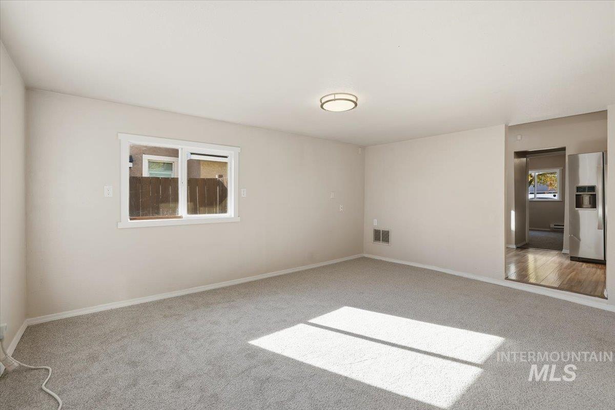 Spare room featuring healthy amount of natural light and carpet flooring