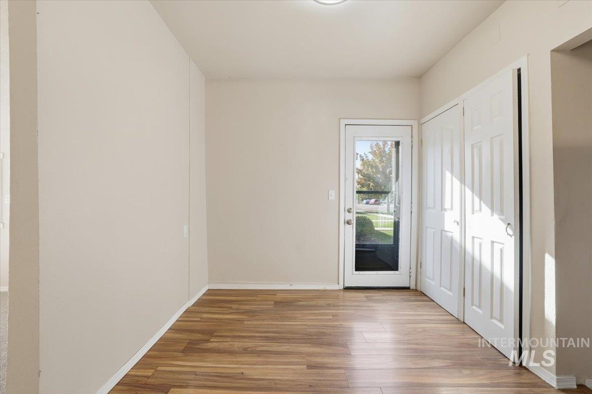 Doorway with baseboards and wood finished floors