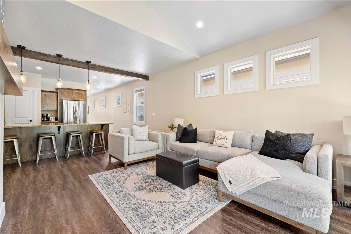 Living room with recessed lighting, dark wood-style flooring, and lofted ceiling