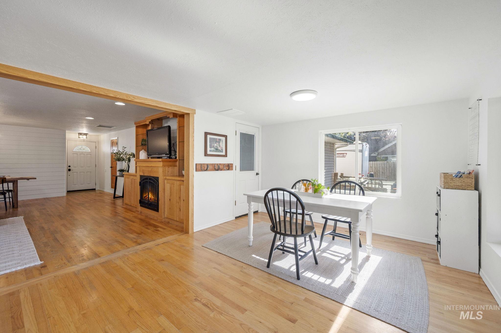 Dining room with light wood-type flooring and a fireplace