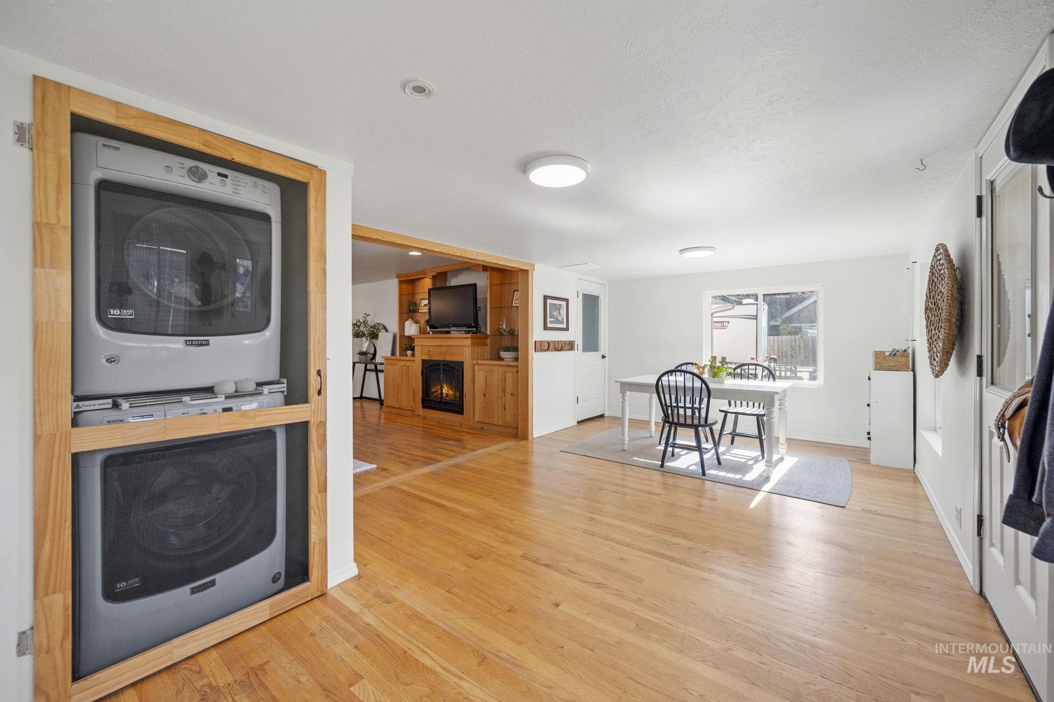 Kitchen featuring light wood finished floors, estacked washer and dryer, a fireplace, and double oven