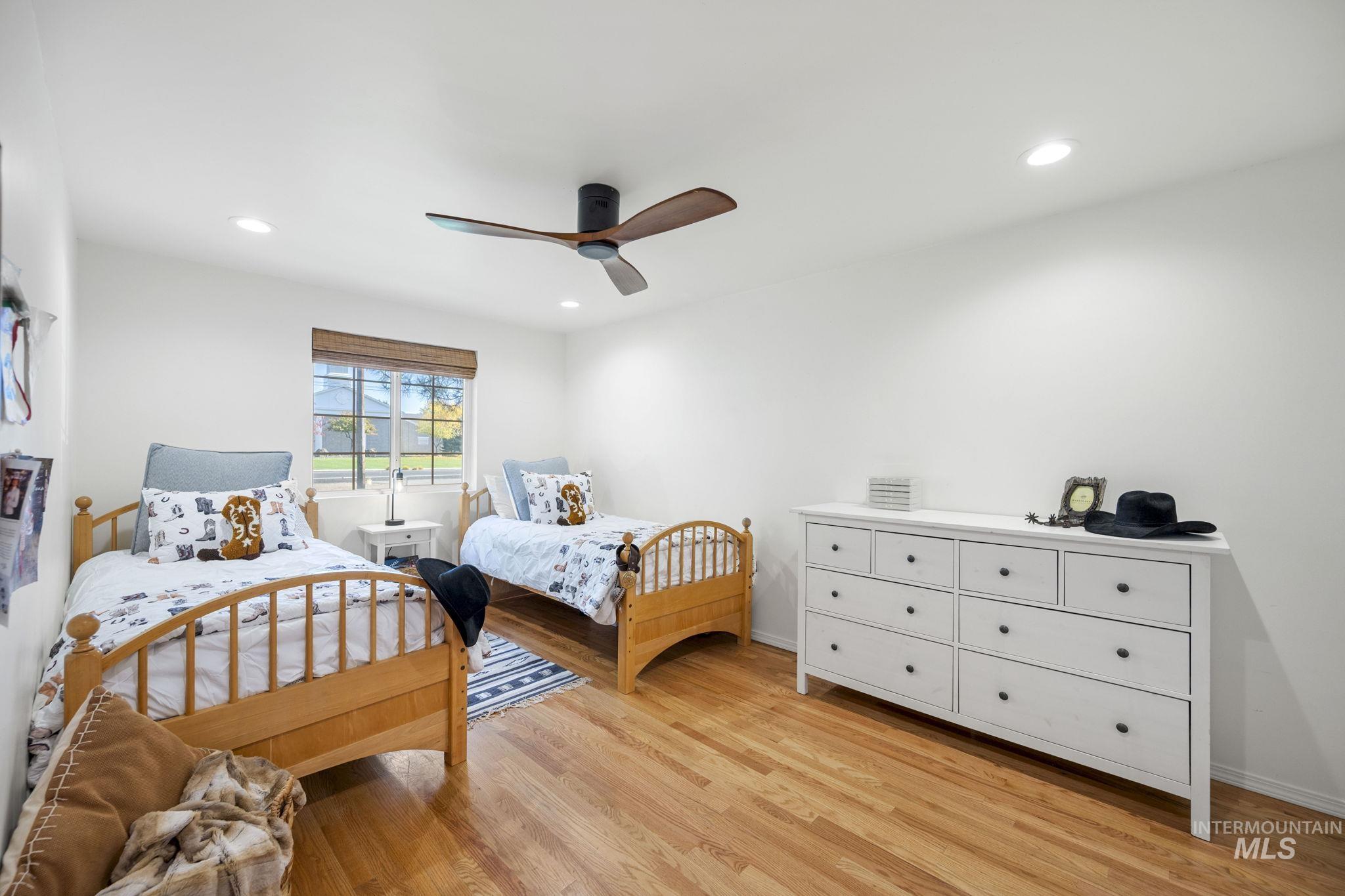 Bedroom with light wood-style floors, a ceiling fan, and recessed lighting
