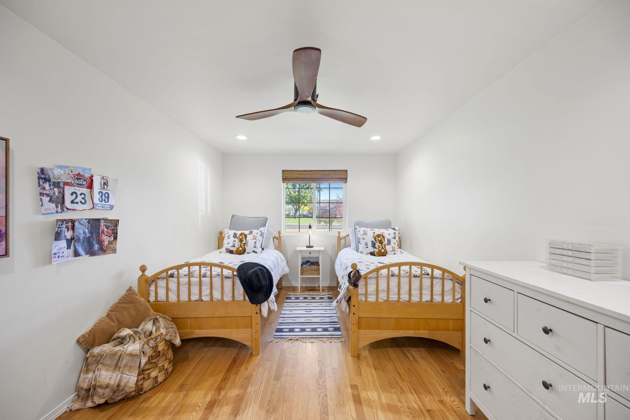 Bedroom with light wood-type flooring, ceiling fan, and recessed lighting