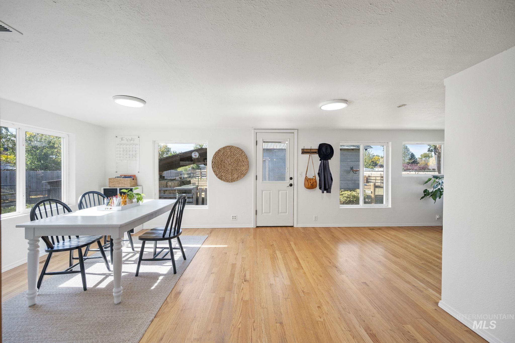 Dining room with light wood finished floors and a textured ceiling