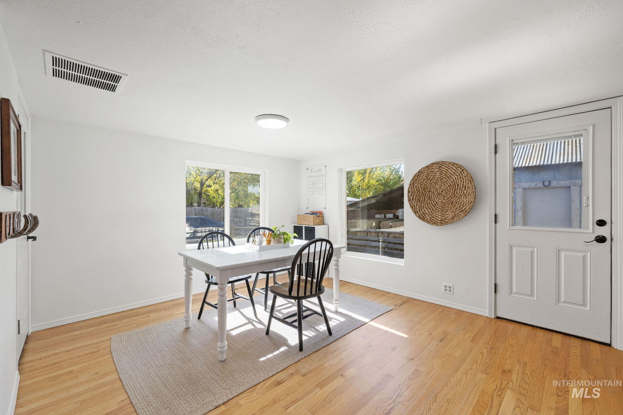 Dining area with light wood-type flooring and a textured ceiling