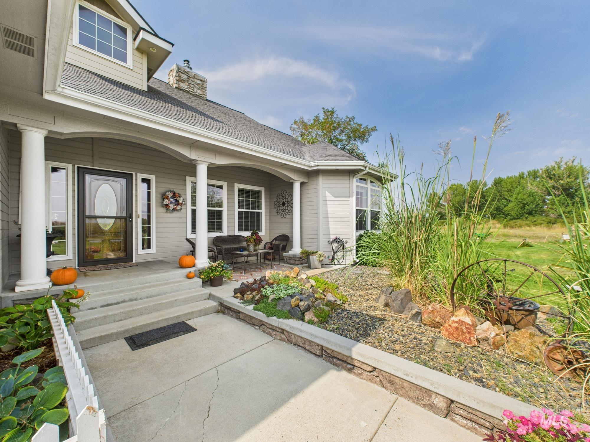 Entrance to property with a shingled roof, a chimney, and a patio
