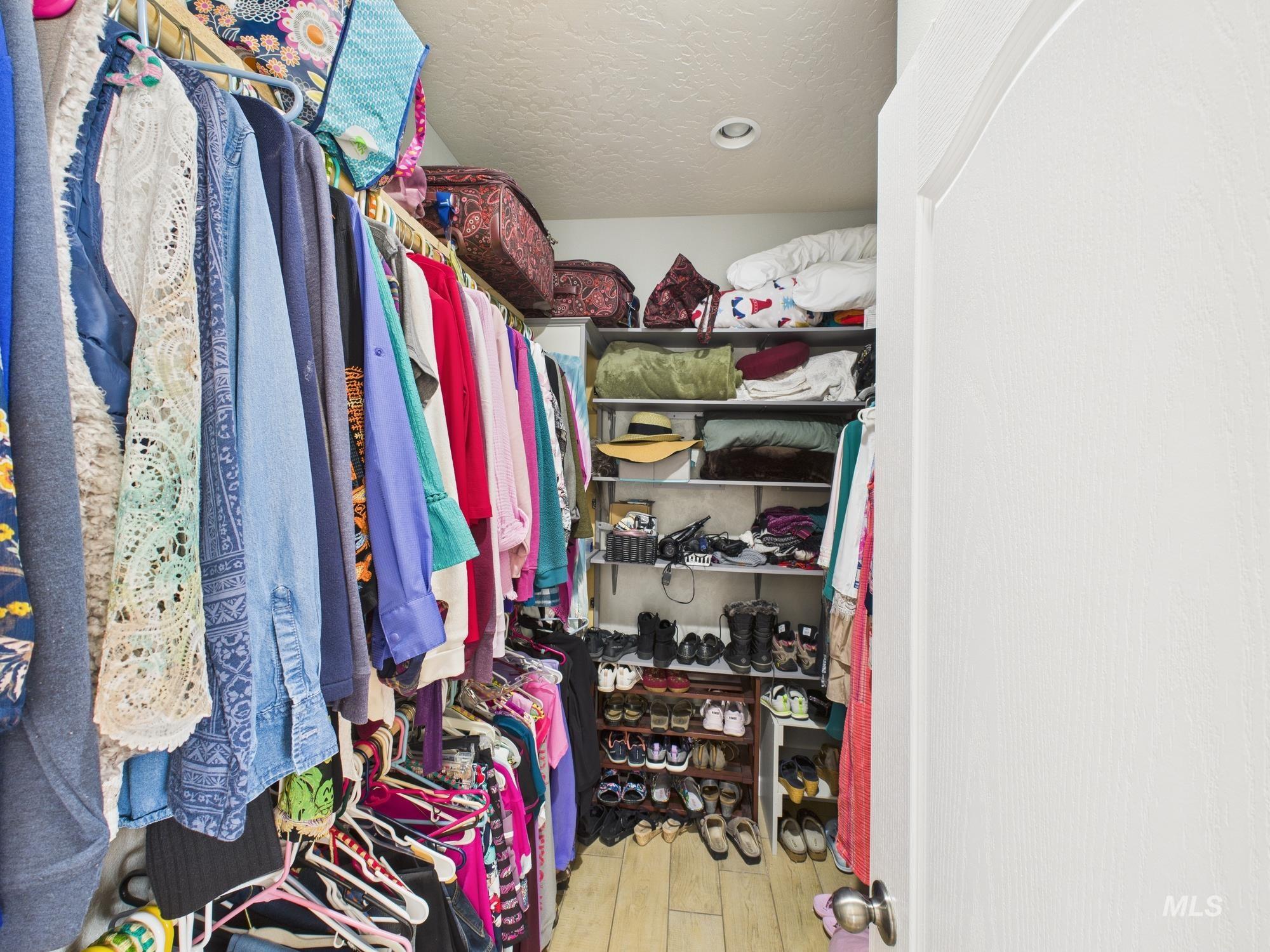 Walk in closet with light wood finished floors