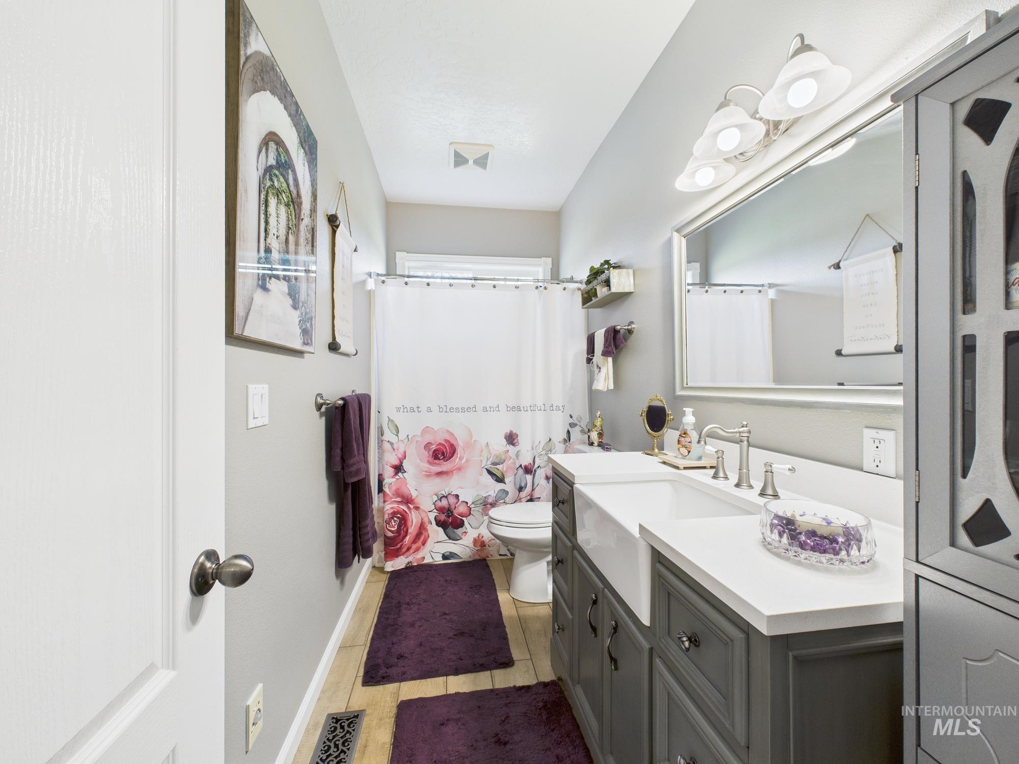 Bathroom featuring a shower with shower curtain, vanity, and light wood-type flooring