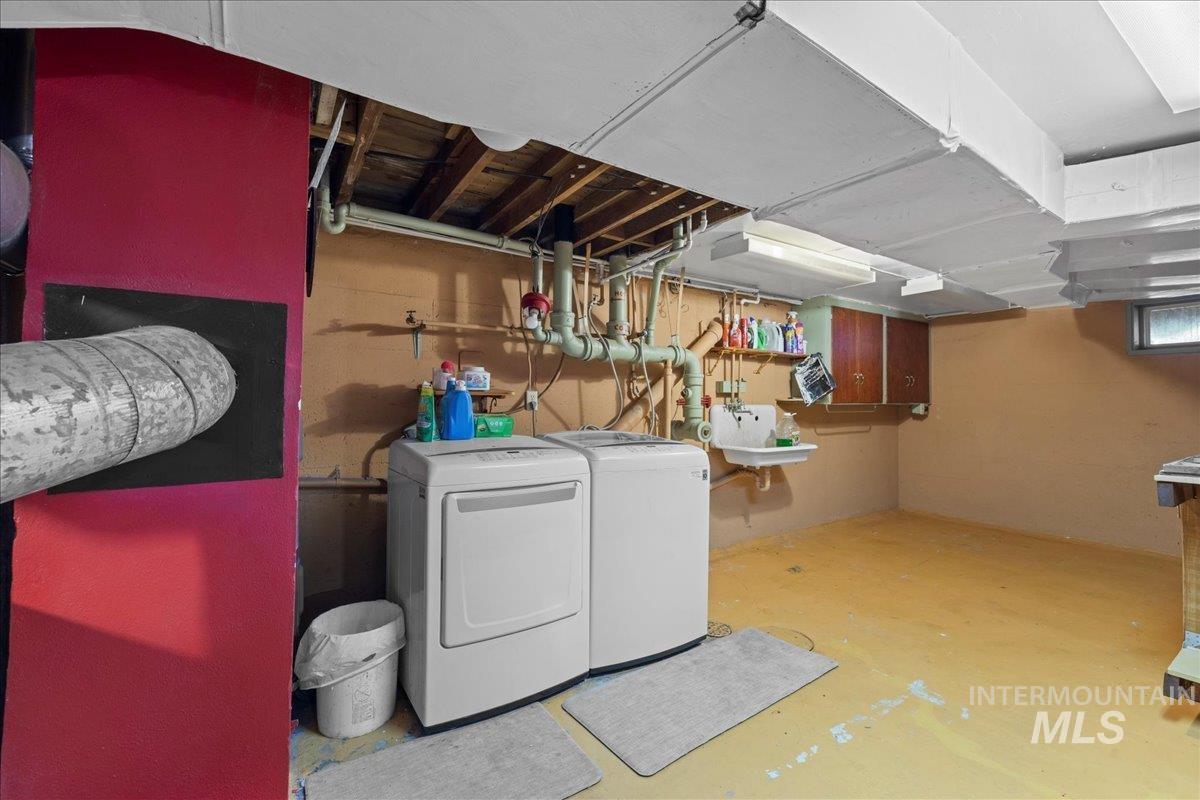 Washroom featuring unfinished concrete floors and independent washer and dryer