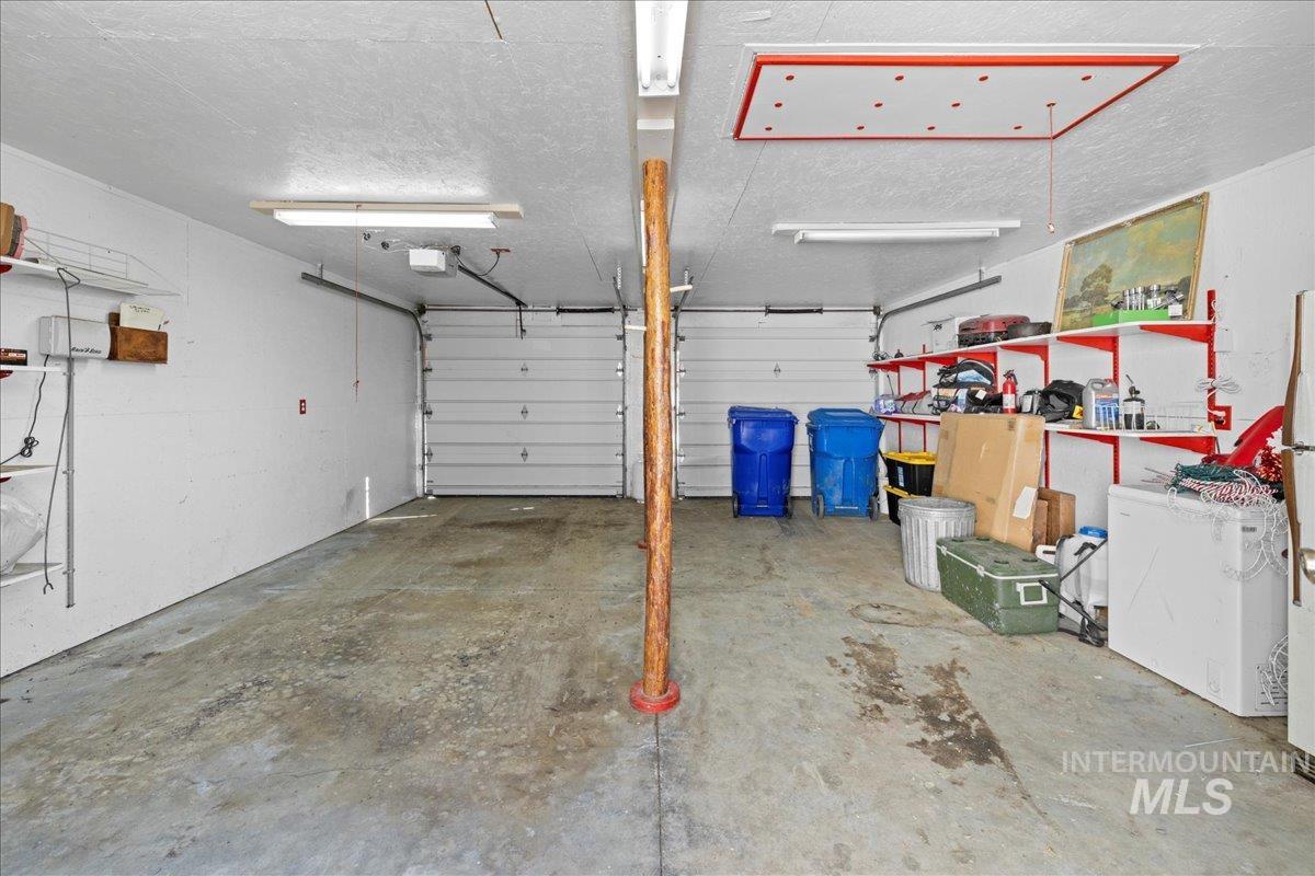 Garage featuring white fridge and a garage door opener