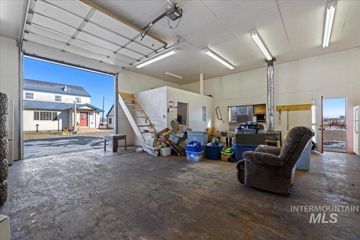 Garage featuring a garage door opener and freestanding refrigerator