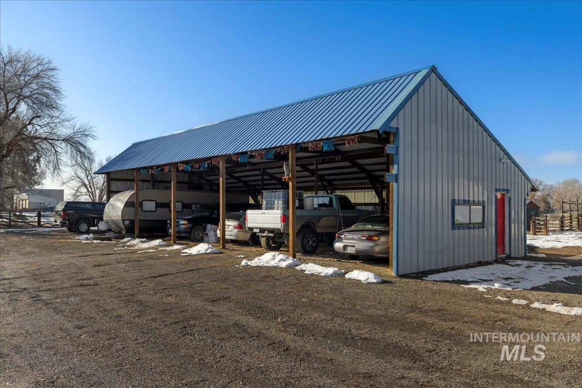 View of parking / parking lot with a pole building and a detached carport
