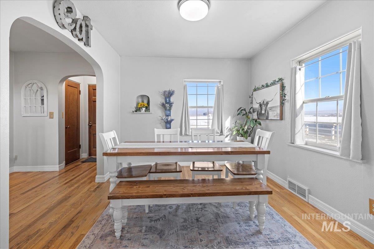 Dining room featuring light wood finished floors and arched walkways