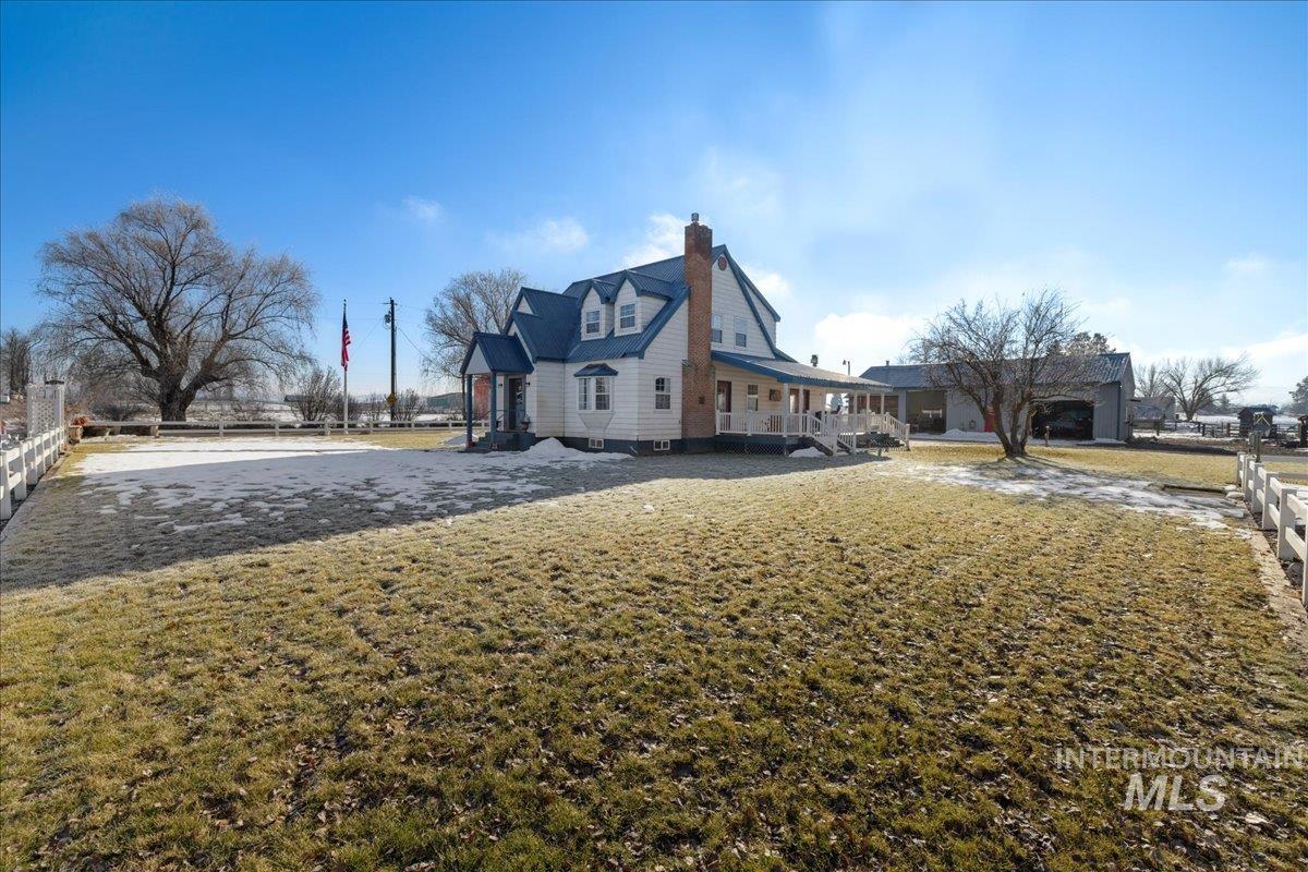View of side of home with a chimney and a porch