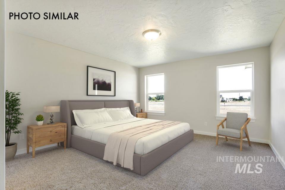 Bedroom featuring carpet flooring and a textured ceiling