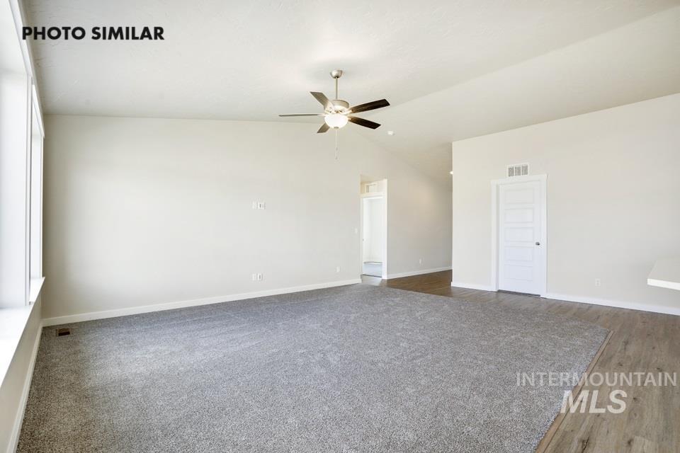 Spare room featuring lofted ceiling and ceiling fan