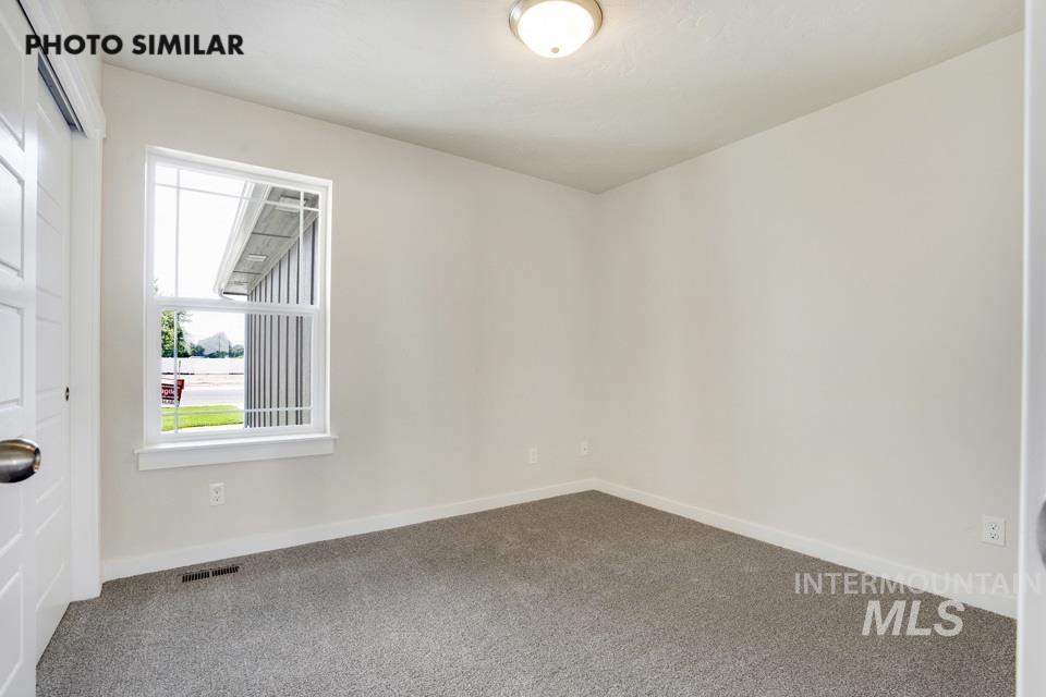 Carpeted empty room with baseboards
