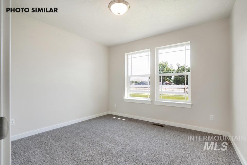 Spare room featuring carpet and baseboards