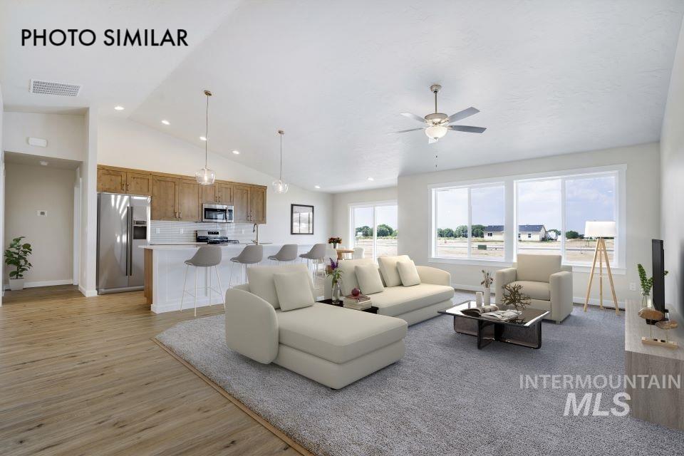 Living room featuring light wood finished floors, a ceiling fan, high vaulted ceiling, and recessed lighting