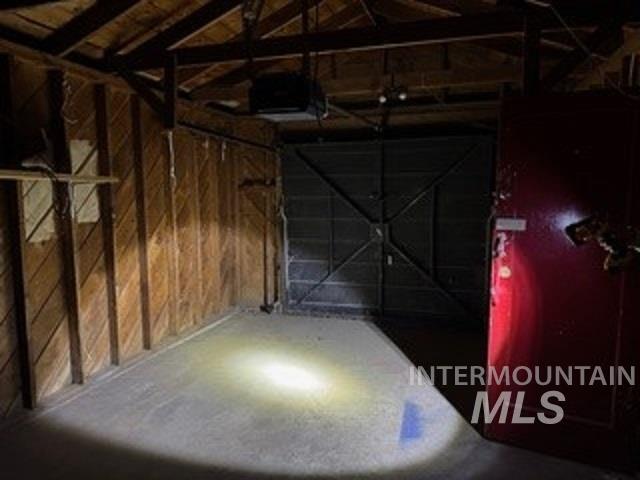 Garage featuring wooden walls and a garage door opener