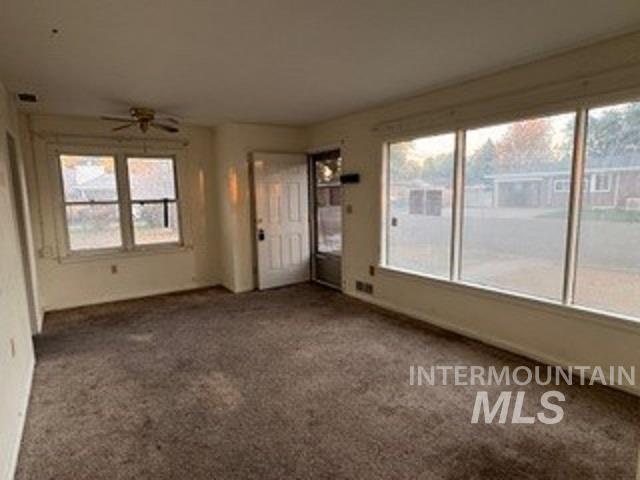 Unfurnished living room with carpet and ceiling fan