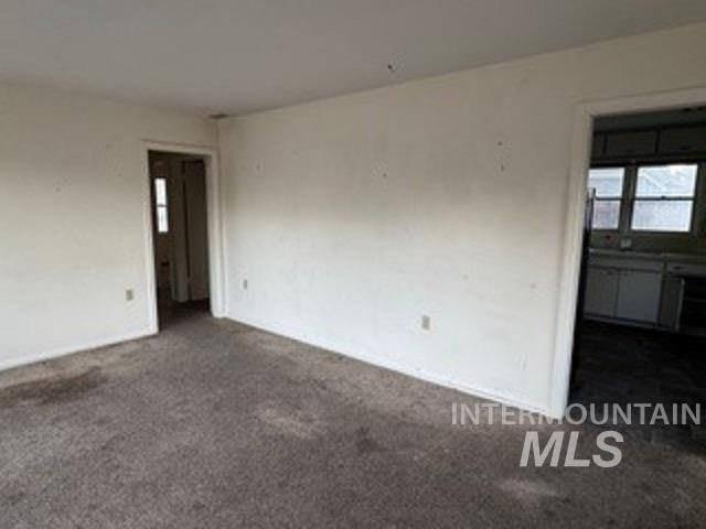 Unfurnished room with dark colored carpet