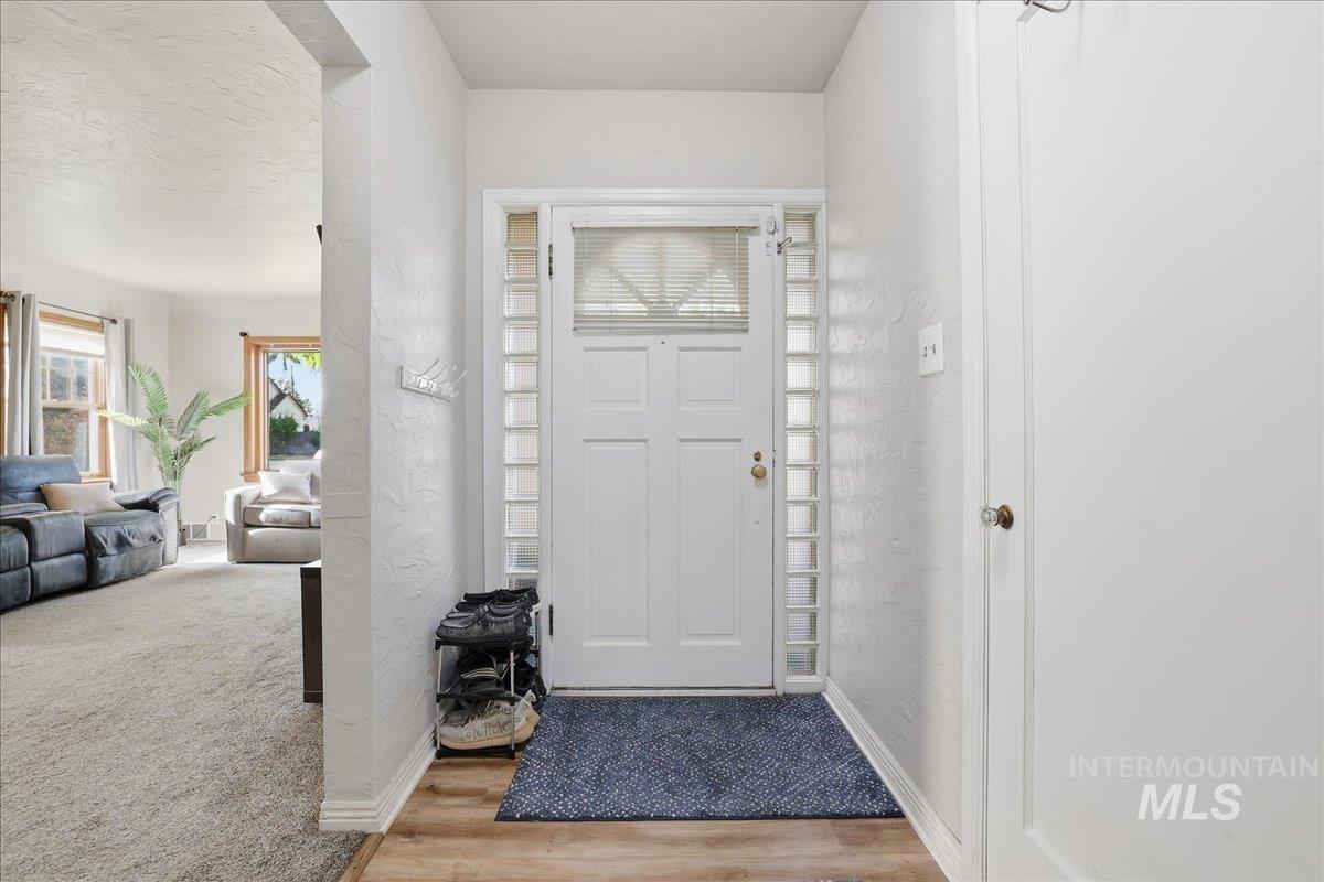 Foyer with a textured wall, plenty of natural light, wood finished floors, and a textured ceiling