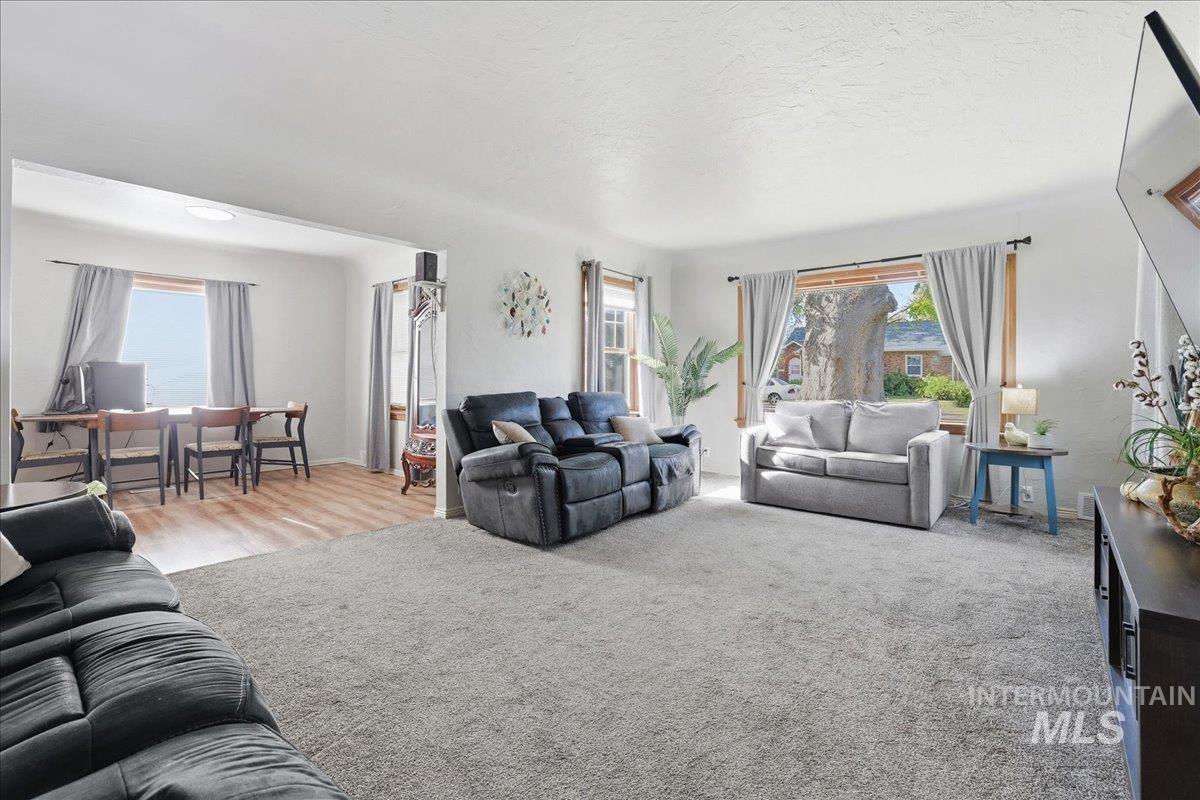 Living area with plenty of natural light, carpet floors, and a textured ceiling