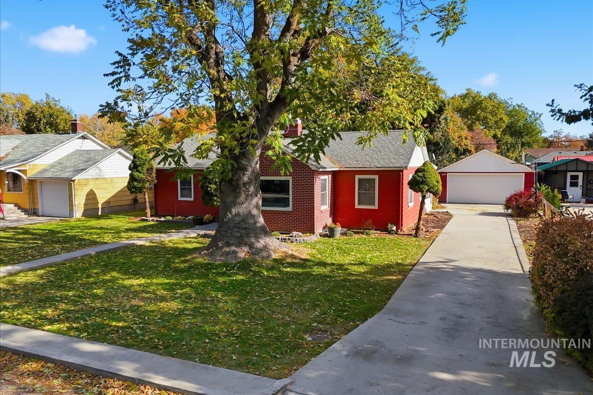 View of front of house featuring an outbuilding, a front lawn, and a detached garage