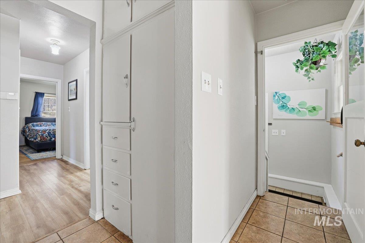 Corridor featuring light tile patterned floors and baseboards