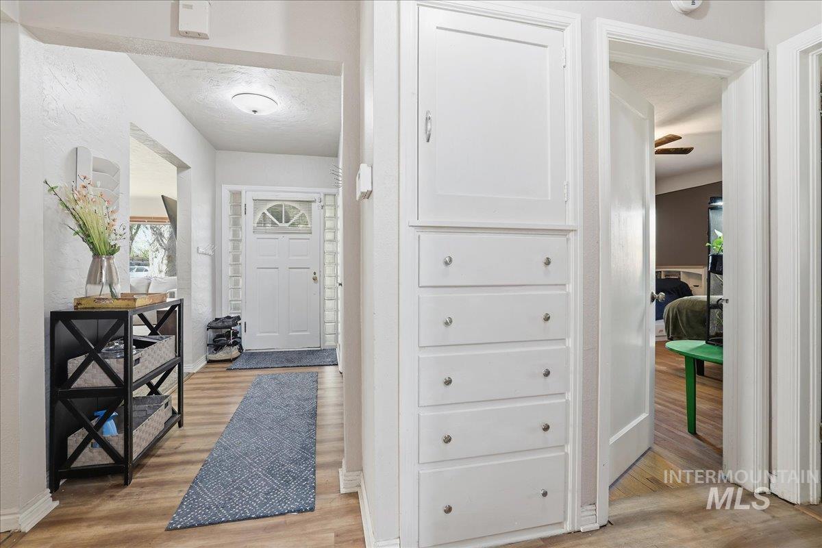 Corridor featuring light wood-style floors and a textured ceiling