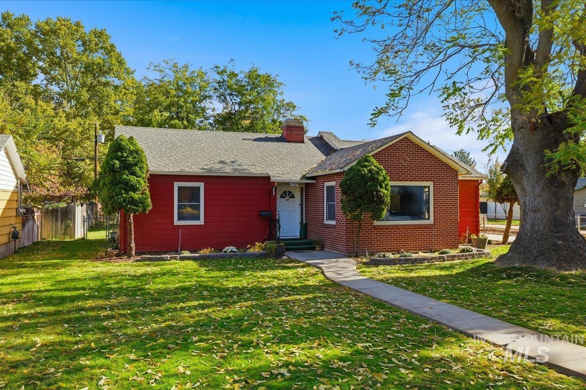 View of front of property with a chimney and brick siding