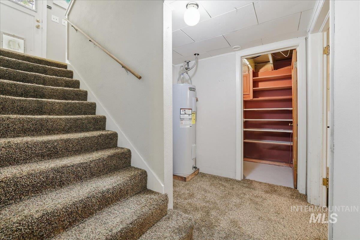 Stairs featuring carpet floors and electric water heater
