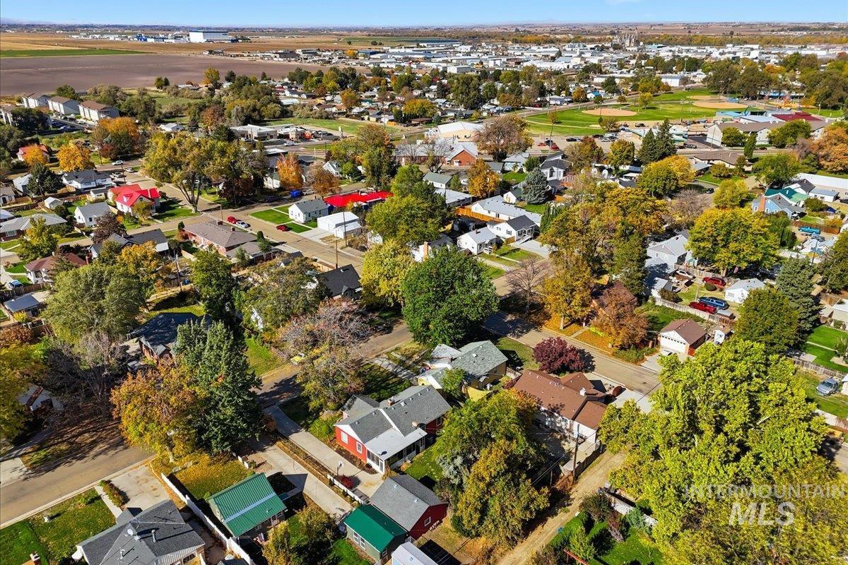 Aerial view of property and surrounding area featuring nearby suburban area