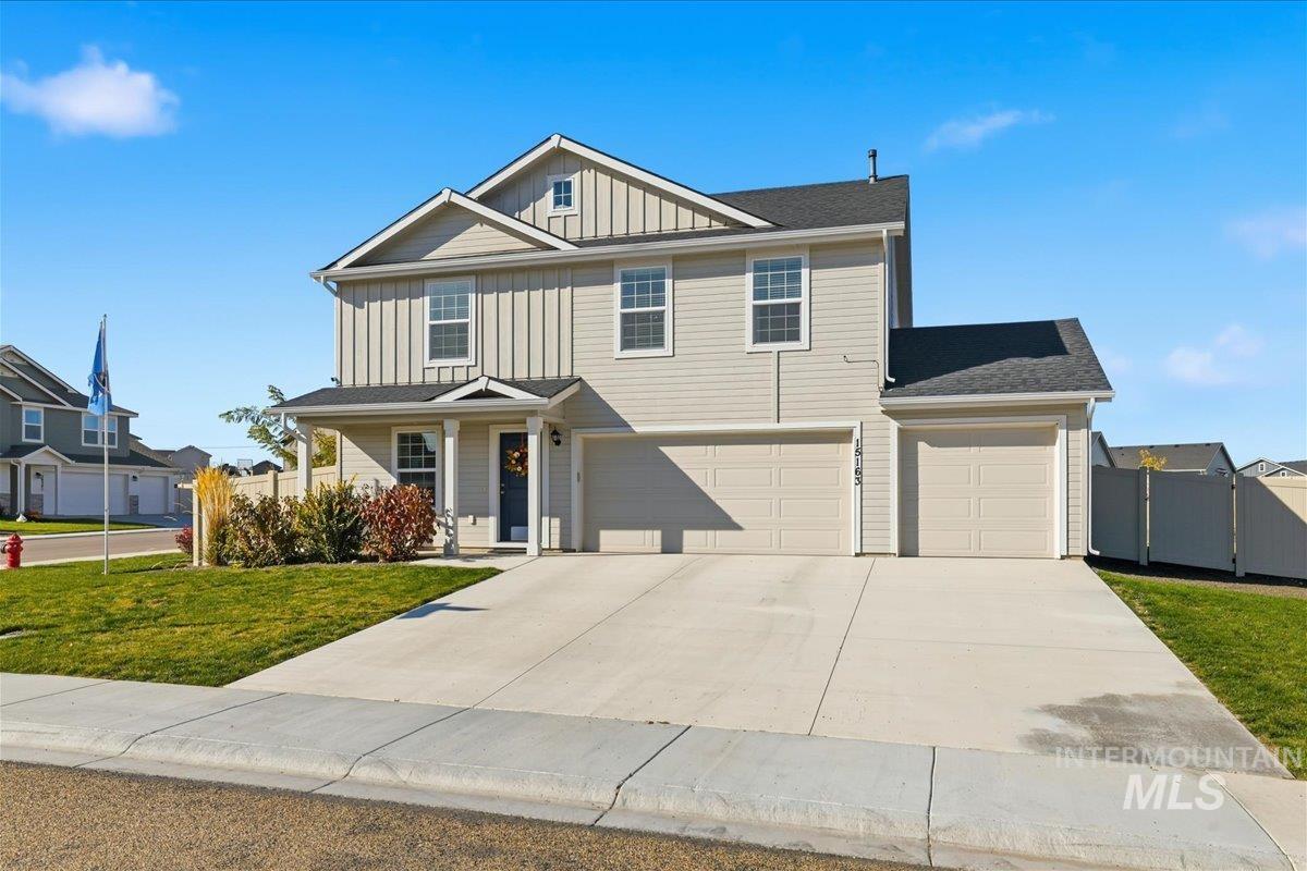 View of front of property featuring board and batten siding, concrete driveway, a shingled roof, a garage, and a porch