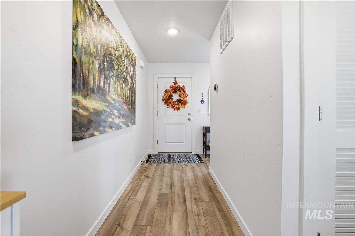 Hallway featuring light wood-style flooring and baseboards