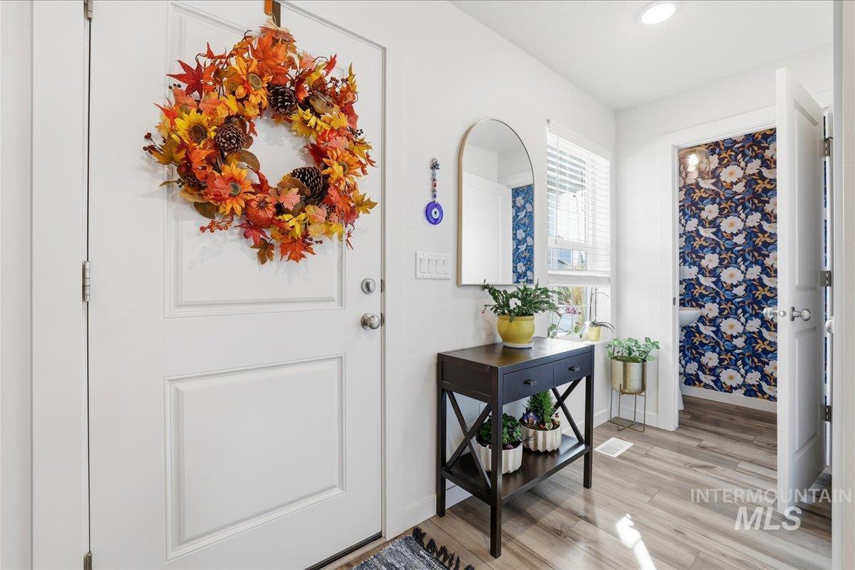 Foyer with light wood finished floors and recessed lighting