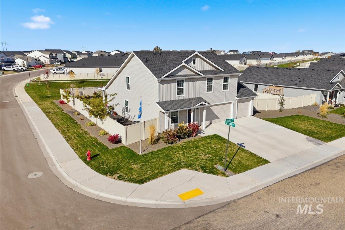 View of front of house featuring board and batten siding, a porch, a residential view, concrete driveway, and an attached garage