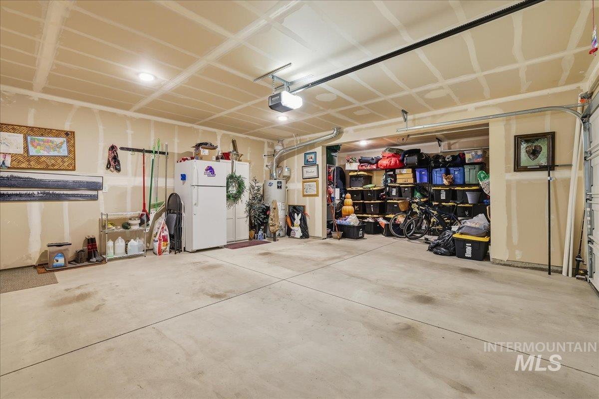 Garage featuring gas water heater and a garage door opener
