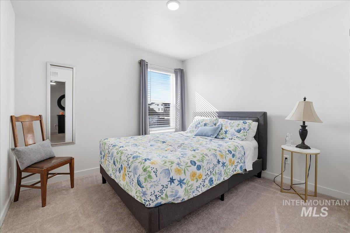 Bedroom with light colored carpet and baseboards