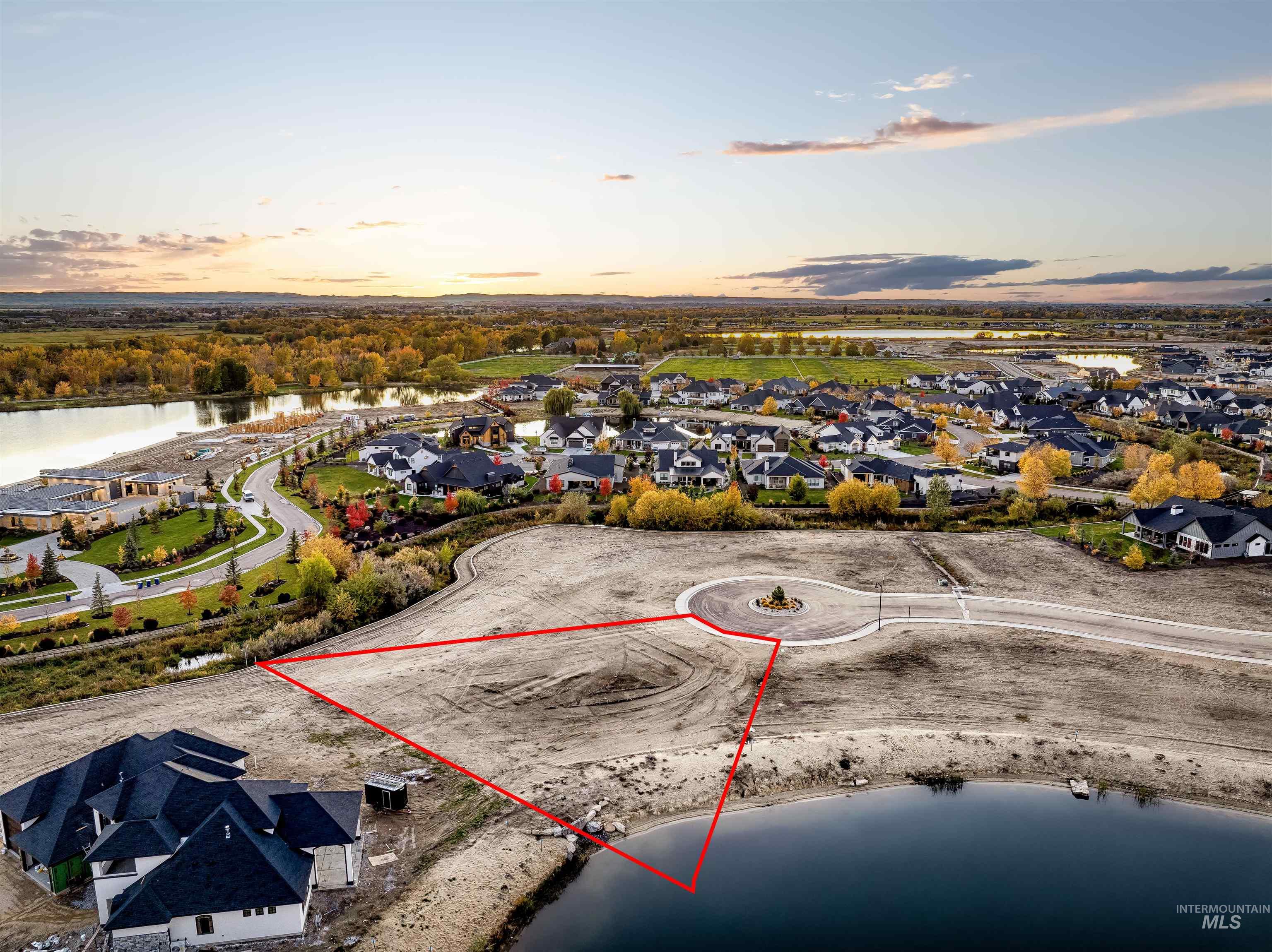 Aerial view at dusk of a residential view, a water view, and property boundaries highlighted