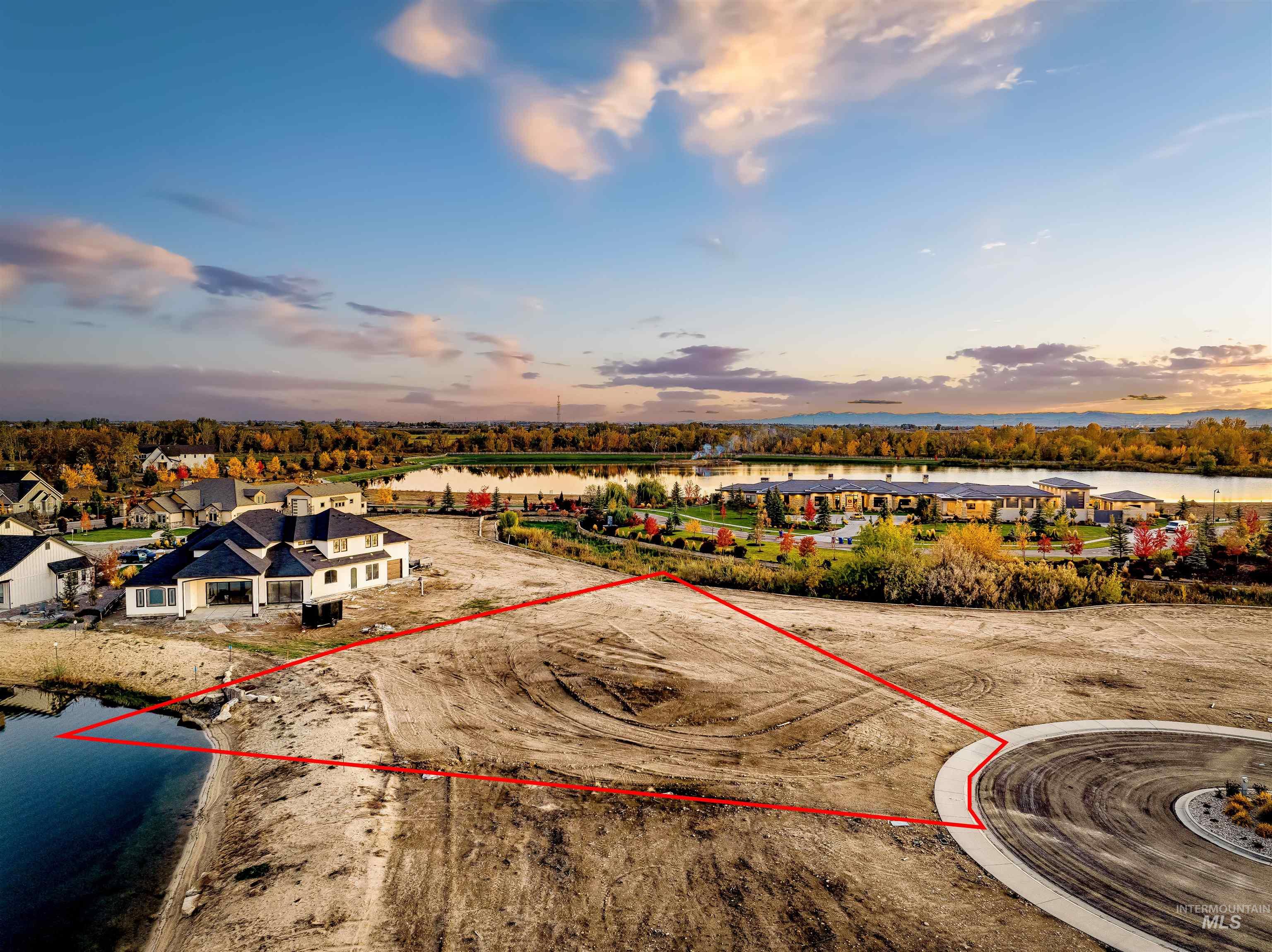 Aerial view of property and surrounding area featuring a nearby body of water and property parcel outlined